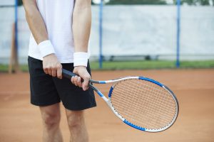 Lesões, Prevenção de Lesões, Tênis : Como prevenir as bolhas nas mãos e nos pés jogando tênis? - Blog da Bola de Tênis Delivery - the man is holding a tennis racket